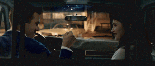 A Man And A Woman Sit In A Car Talking GIF
