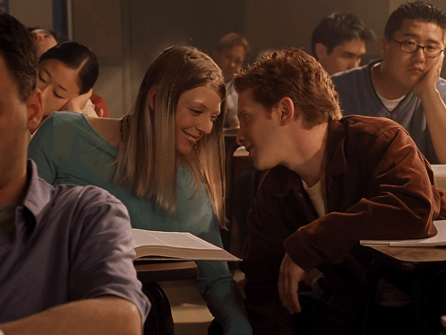 Man And Woman Sitting In Classroom Looking At Each Other GIF