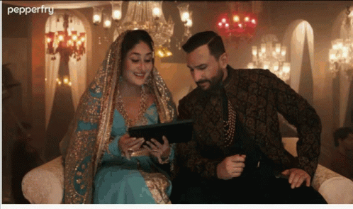 A Man And A Woman Sit On A Couch Looking At A Tablet And The Word Pepperfry Is On The Bottom GIF