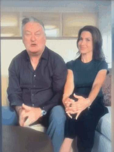 Man And Woman Sitting On Couch With Folded Hands GIF