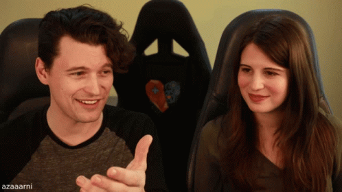 A Man And A Woman Sitting Next To Each Other With Azaarni Written On The Bottom Right GIF