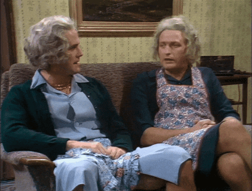 A Man And A Woman Sitting On A Couch Talking GIF
