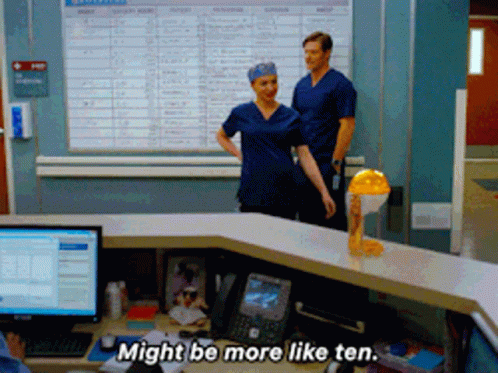 Man And Woman In Front Of Desk Say Might Be More Like Ten GIF