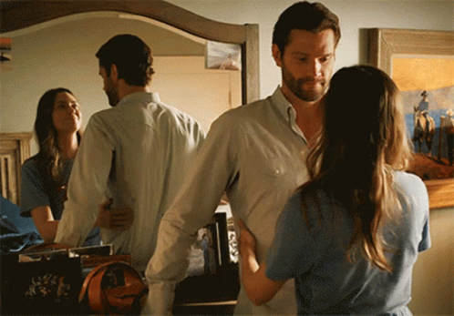 A Man And A Woman Standing In Front Of A Mirror GIF