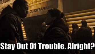 A Man And A Woman Standing In Front Of A Sign That Says " Stay Out Of Trouble Alright " GIF