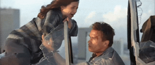 A Man And A Woman Standing Next To Each Other GIF