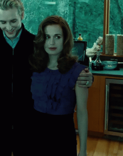 A Man And A Woman Standing Next To Each Other GIF