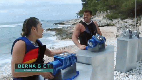 A Man And A Woman Standing On A Beach With The Name Berna & Ct On The Bottom GIF