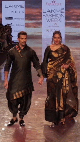 A Man And A Woman Walk Down A Ramp For Lakme Fashion Week GIF