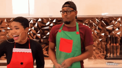A Man And A Woman Wearing Aprons Are Standing Next To Each Other With The Words Terrell.com Below Them GIF
