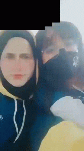 A Man And A Woman Wearing Face Masks Are Posing For A Picture Together . GIF