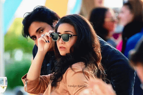 A Man And A Woman Wearing Sunglasses Are Sitting Next To Each Other In A Photo Taken By Vikram Kaurkey GIF