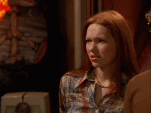 A Man And A Woman With Red Hair Are Standing Next To Each Other GIF