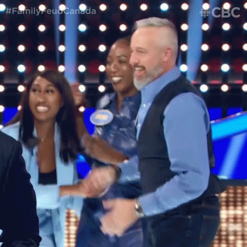 A Man And Two Women Are Dancing On A Stage . GIF