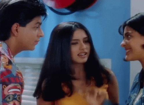 A Man And Two Women Are Standing Next To Each Other And Talking To Each Other . GIF