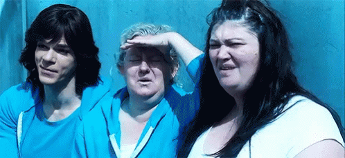 A Man And Two Women Are Standing Next To Each Other In Front Of A Wall . GIF