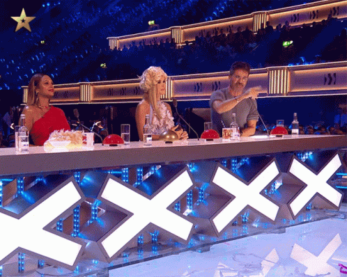 Man And Women Sitting At Table With XXX Sign GIF