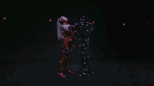 A Man And Woman Are Dancing In A Dark Room GIF