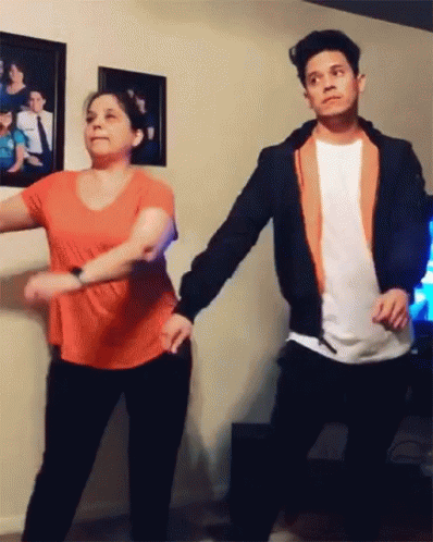 A Man And Woman Are Dancing In A Living Room GIF