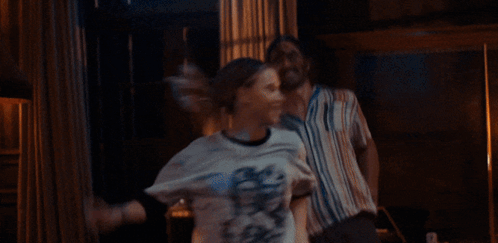 a man and woman are dancing in a room with lamps