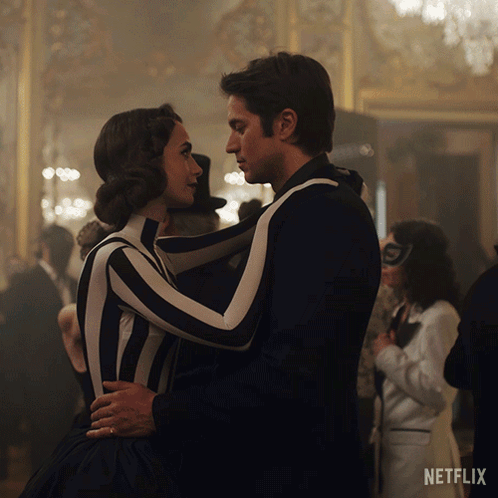 A Man And Woman Are Dancing In Front Of A Netflix Ad GIF