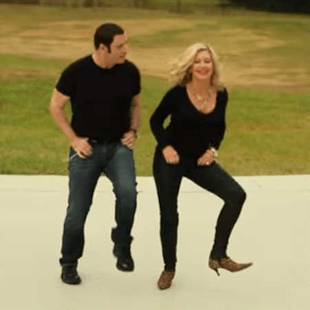 A Man And Woman Are Dancing On A Sidewalk GIF