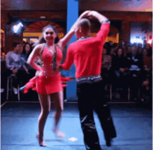 A Man And Woman Are Dancing On A Stage In Front Of A Crowd GIF