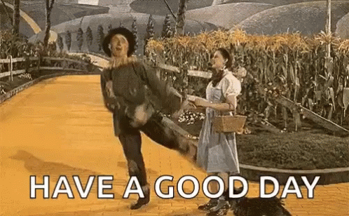 A Man And Woman Are Dancing On A Yellow Brick Road . GIF