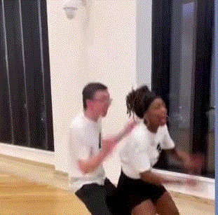 A Man And Woman Are Dancing Together In A Room . GIF
