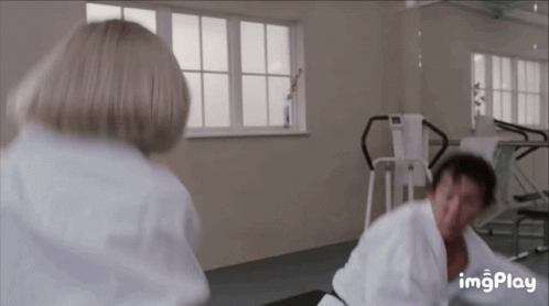A Man And Woman Are Fighting In A Gym . GIF