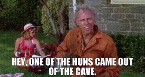 A Man And Woman Are Having A Picnic In The Grass And The Man Is Saying Hey One Of The Huns Came Out Of The Cave GIF