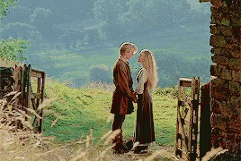 A Man And Woman Are Holding Hands In A Field GIF
