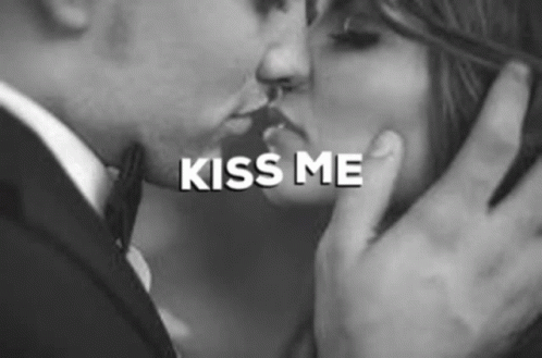 A Man And Woman Are Kissing In A Black And White Photo . GIF