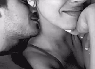 A Man And Woman Are Kissing In A Black And White Photo . GIF