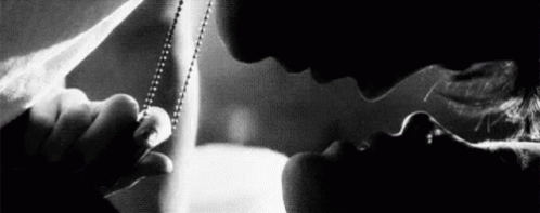 A Man And Woman Are Kissing In A Black And White Photo . GIF