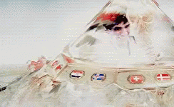A Man And Woman Are Kissing In A Futuristic Space Ship . GIF