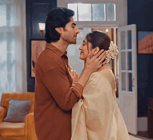 A Man And Woman Are Kissing In A Living Room GIF