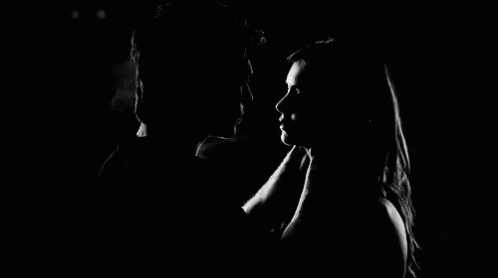 A Man And Woman Are Kissing In The Dark . GIF