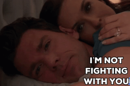 a man and woman are laying on a bed with the words i 'm not fighting with you