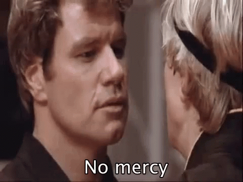 A Man And Woman Are Looking At Each Other And The Man Is Saying `` No Mercy '' . GIF
