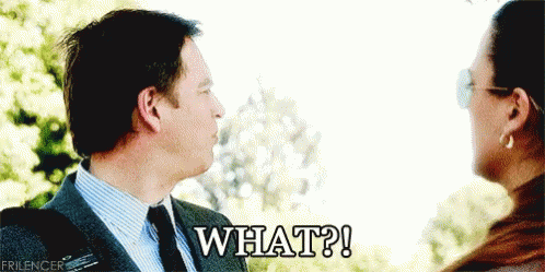 A Man And Woman Are Looking At Each Other And The Man Is Saying " What " GIF