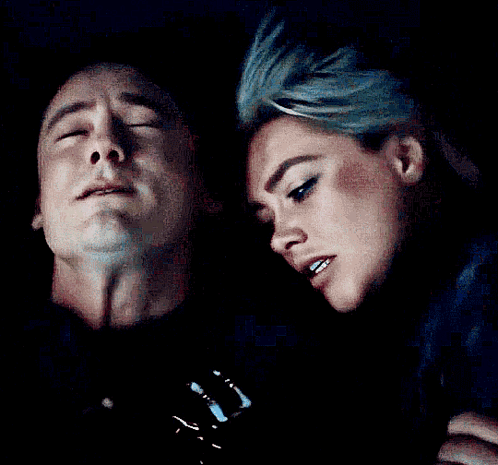 A Man And Woman Are Looking At Each Other In The Dark GIF