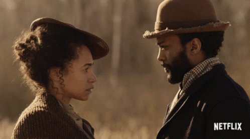 A Man And Woman Are Looking At Each Other With A Netflix Logo In The Corner GIF