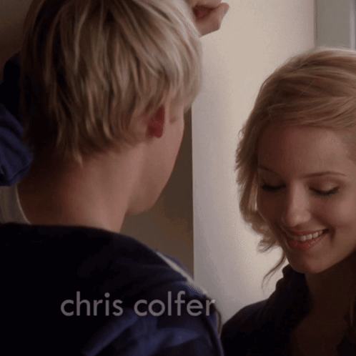 A Man And Woman Are Looking At Each Other With The Name Chris Colfer On The Bottom GIF