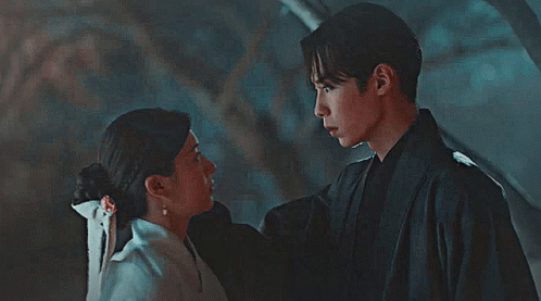 A Man And Woman Are Looking Into Each Other 'S Eyes GIF