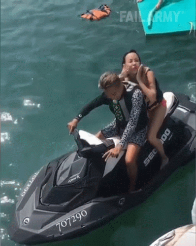 A Man And Woman Are Riding A Jet Ski With The Number 707290 GIF