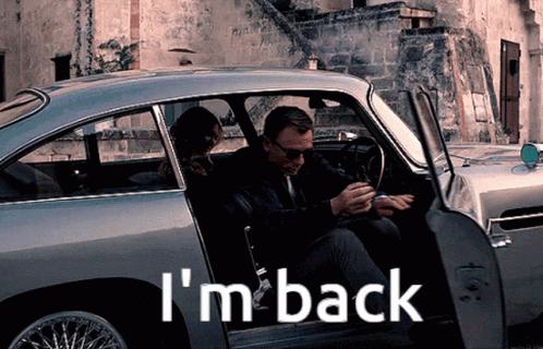 A Man And Woman Are Sitting In A Car With The Words I 'M Back On The Side GIF