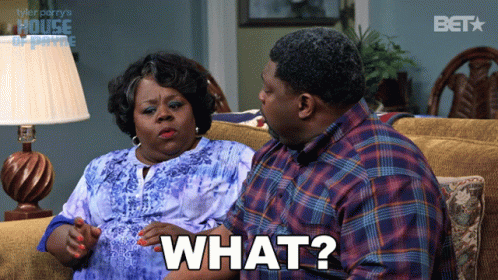 A Man And Woman Are Sitting On A Couch And The Man Is Saying " What " GIF