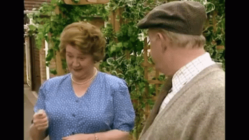 A Man And Woman Are Standing Next To Each Other And Talking GIF