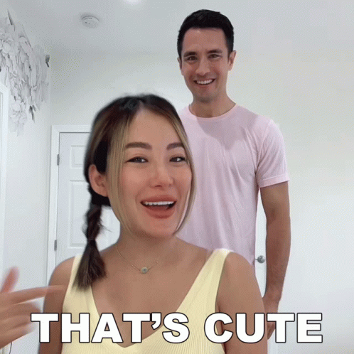 A Man And Woman Are Standing Next To Each Other And The Woman Is Pointing At The Man And Saying That 'S Cute GIF